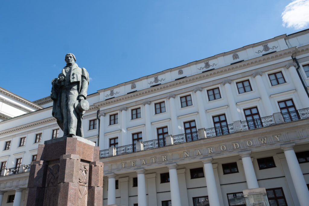 Na zdjęciu widać fasadę Teatru Narodowego i pomnik Wojciecha Bogusławskiego. 
